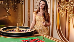 An Evolution croupier next to the roulette wheel.